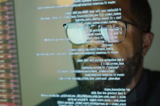 Man studying a see-through display depicting Python computer coding.
